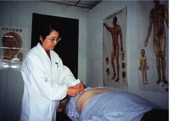 Caiping Lin performs acupuncture on a client